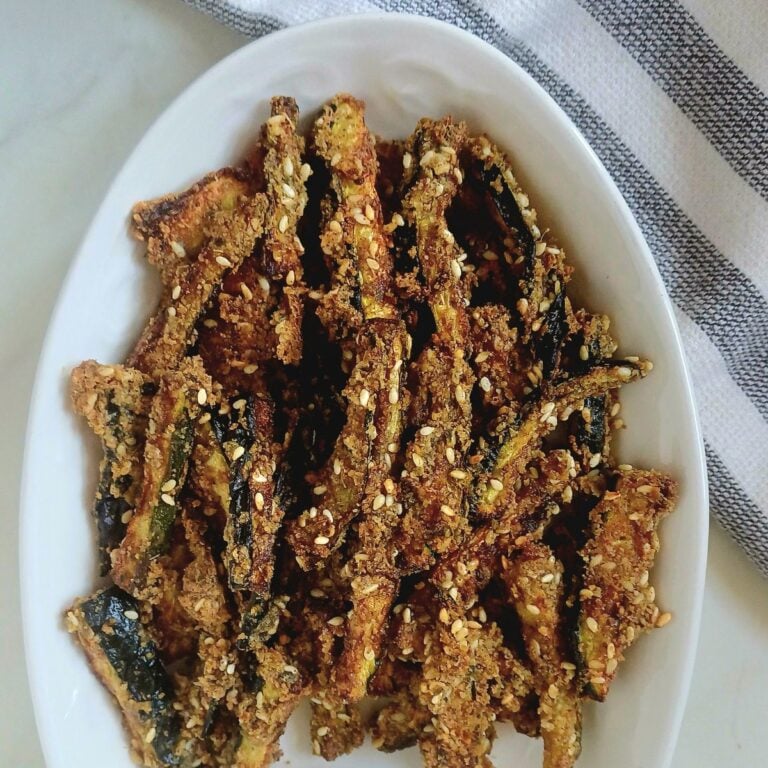 white plate of crispy baked zucchini sticks.