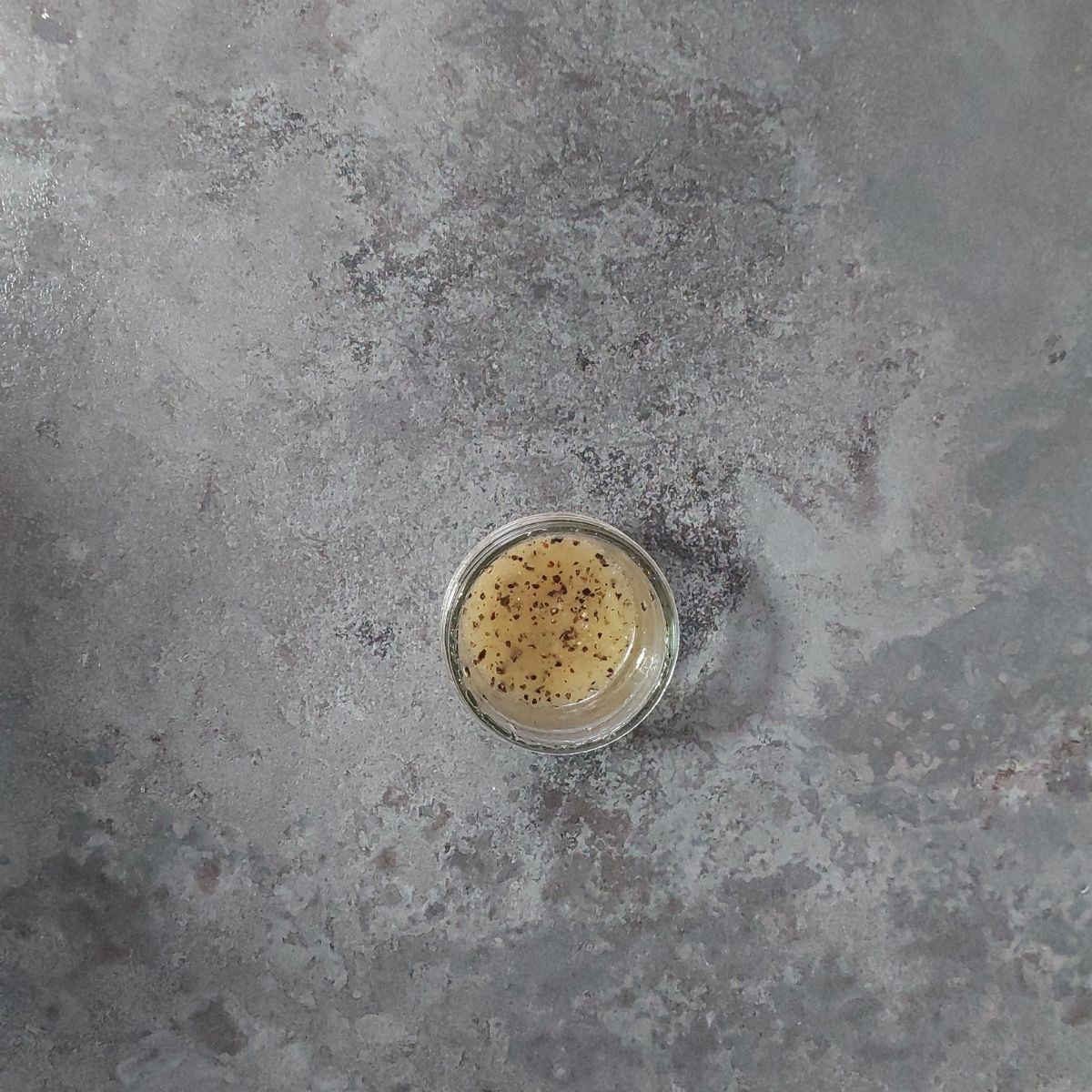 jar of apple salad dressing placed on black granite.