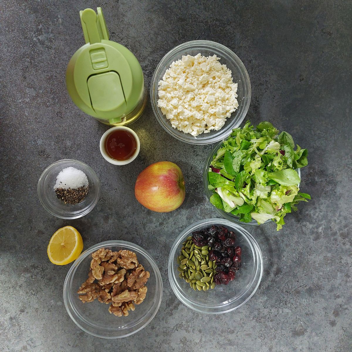 apple walnut salad ingredients on dark grey platform.