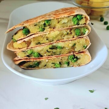 stacked potato peas quesadilla on a white plate.