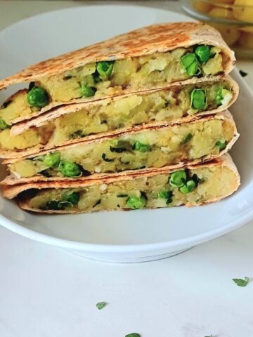 stacked potato peas quesadilla on a white plate.