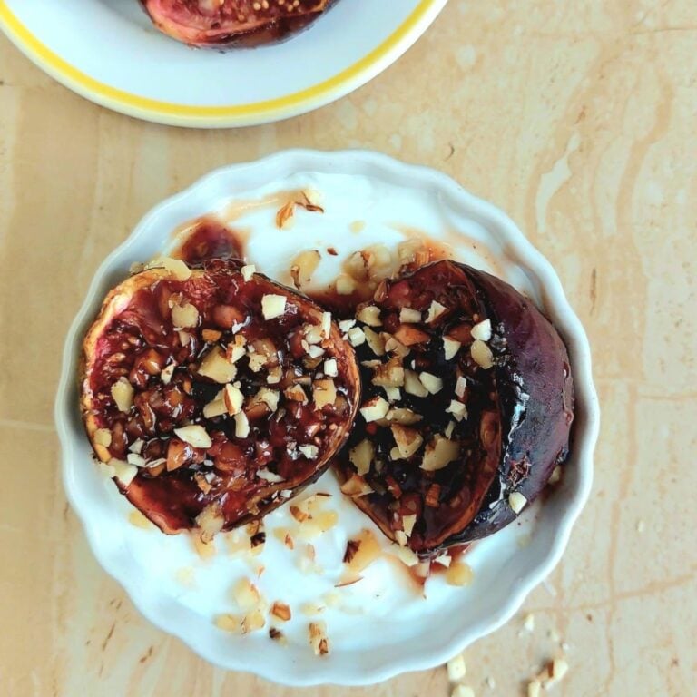 top view of white yogurt bowl topped with oven baked figs and nuts.