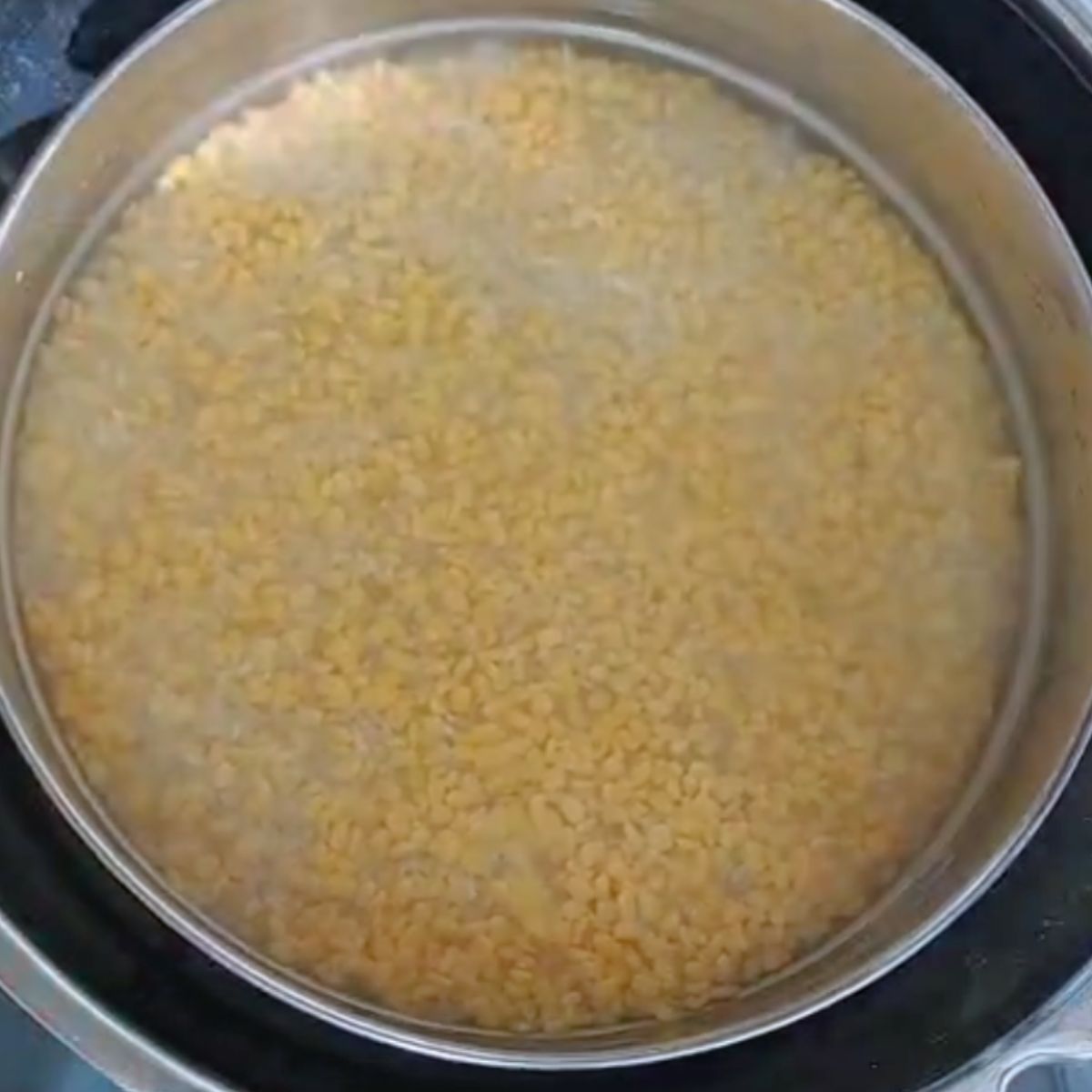 steel container with rice, lentil and water.