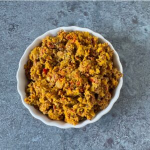 white bowl filled with amla thokku placed on textured tile.