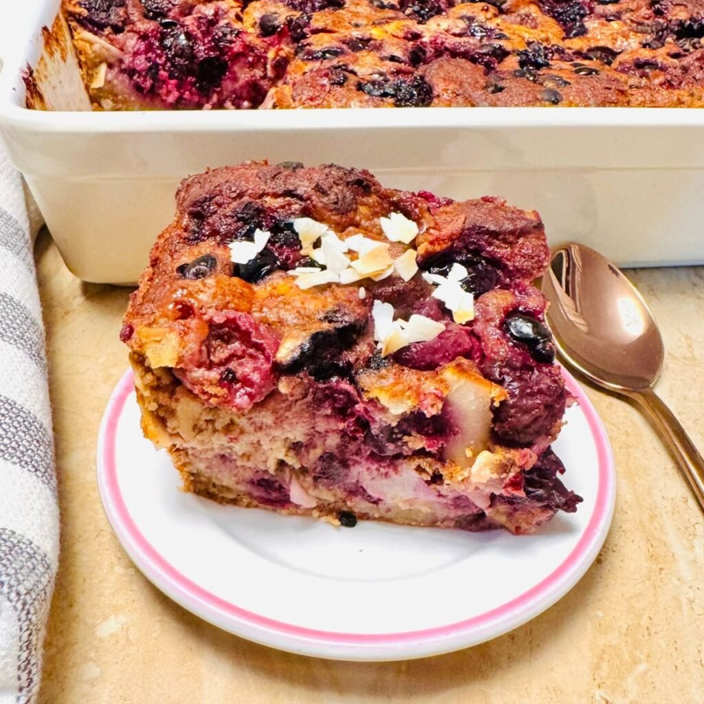 a slice of black forest fruit breakfast baked oatmeal on a white plate.