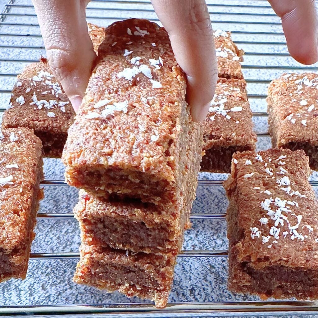 child picking up 4 ingredient carrot oatmeal breakfast bar from a stack.