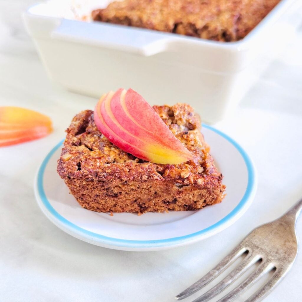white plate of apple cinnamon baked oatmeal placed on a marble along with a fork.