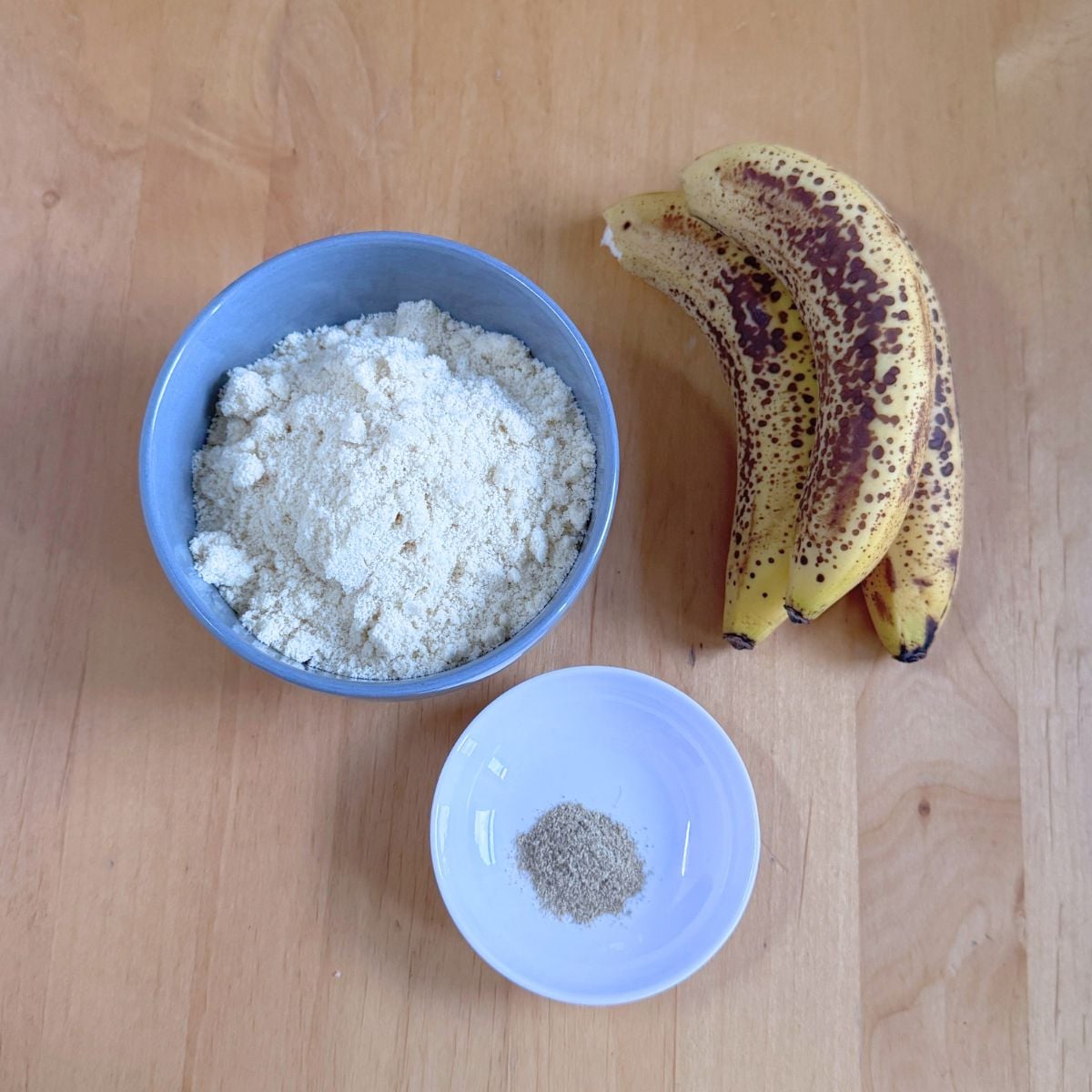 bananas, flour and cardamom placed on wooden table.