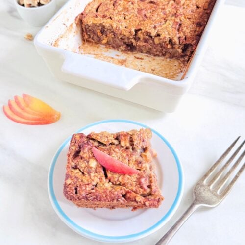 top view of a slice of apple cinnamon baked oatmeal on white plate topped with apple slices.