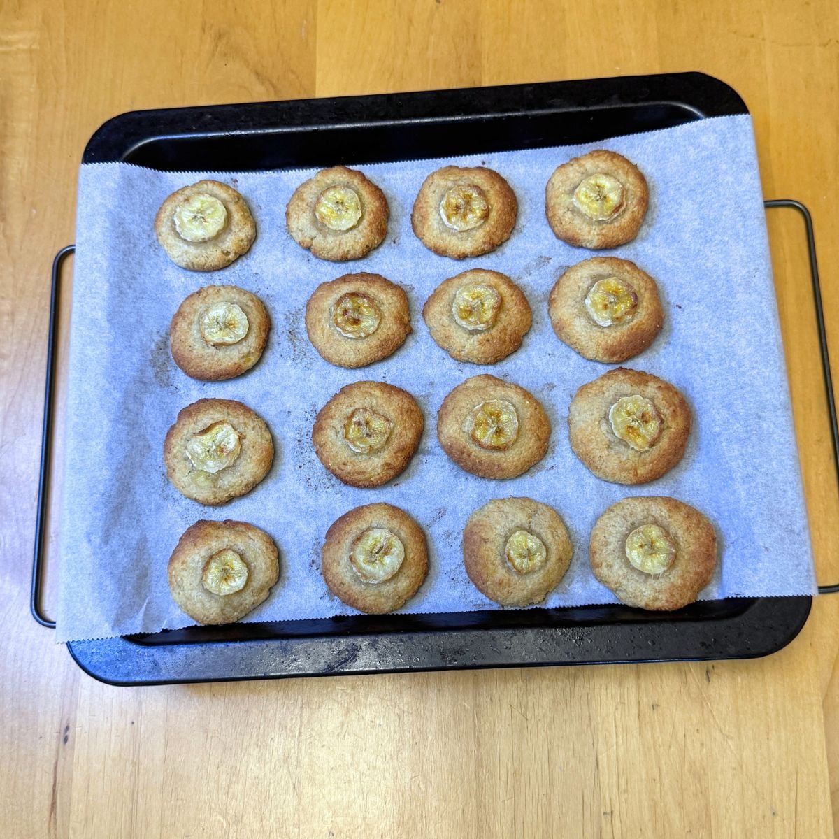 baked toddler friendly 3 ingredient banana almond cookies on lined baking tray.