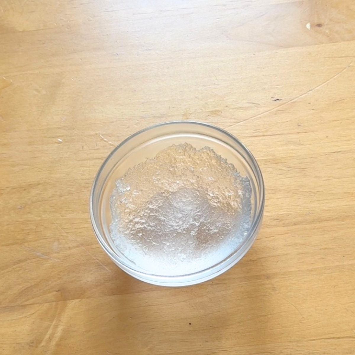 glass bowl with transparent jelly like gond katira placed on wooden table.