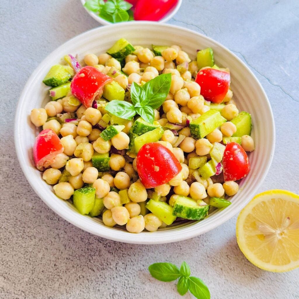 top view of bowl filled with spicy chickpea salad with lemon basil dressing placed on granite