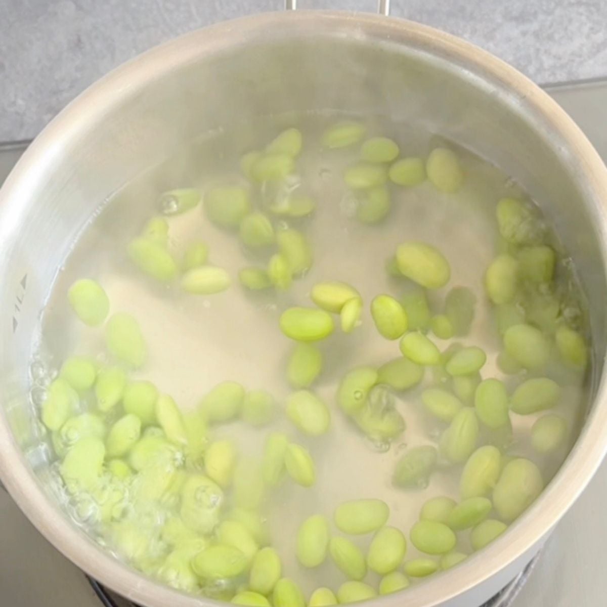boiling edamame in steel pot.
