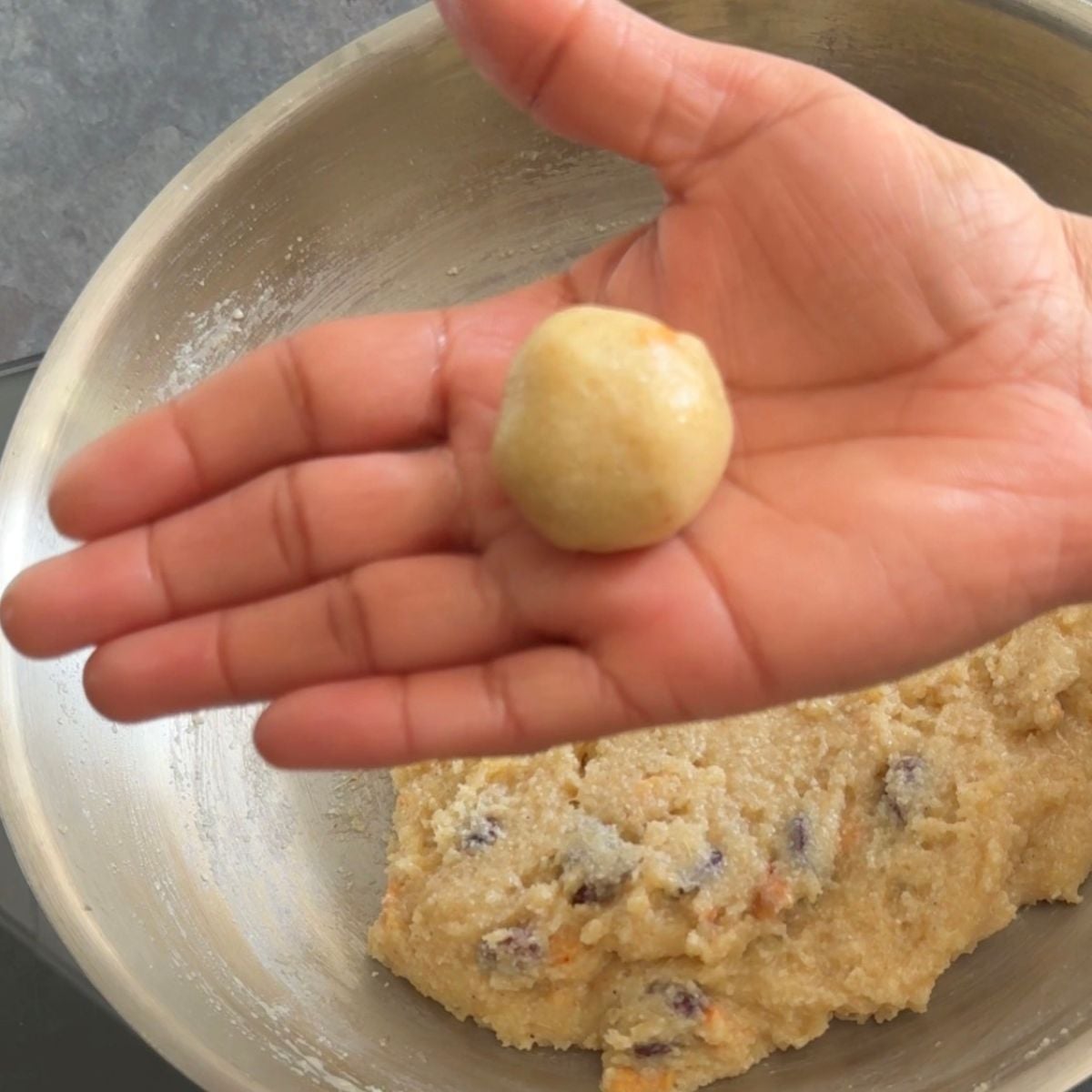 holding shaped rava laddu in a palm.