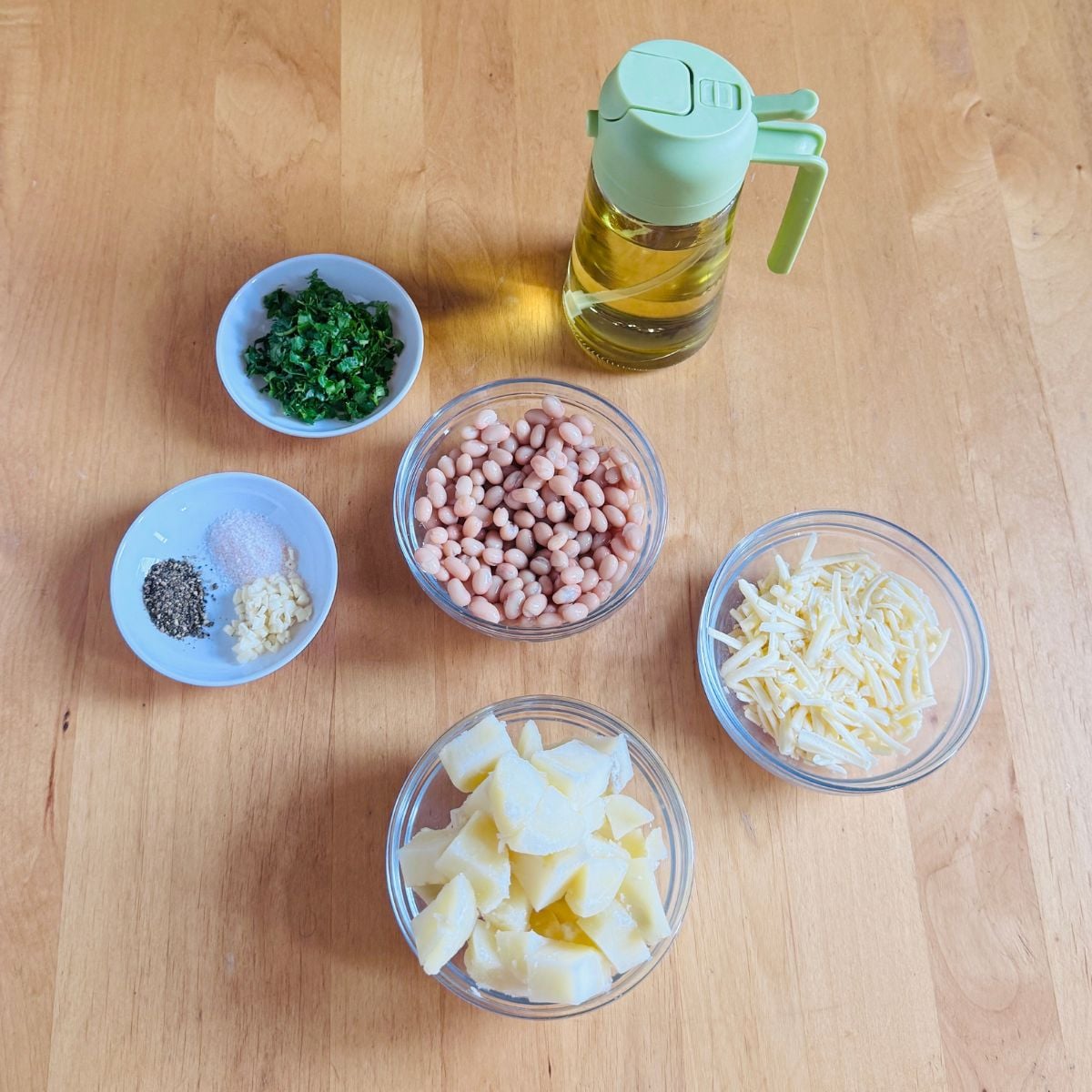ingredients to make bean potato cheese patties placed on wooden table.