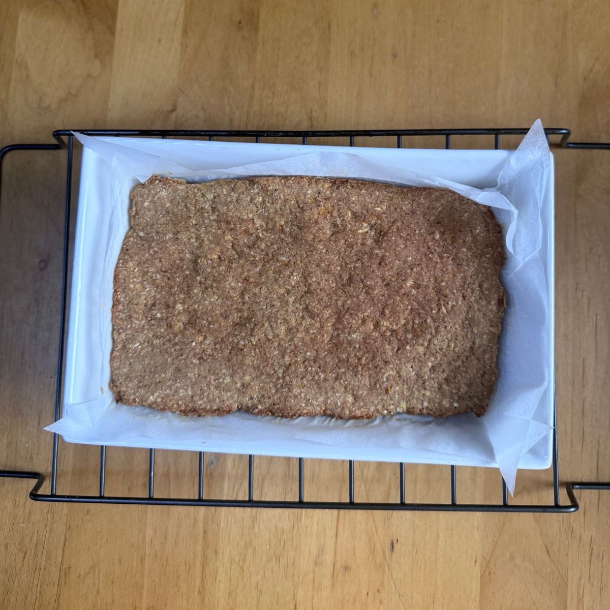 baked apple oat bar on a baking dish placed on wooden table.