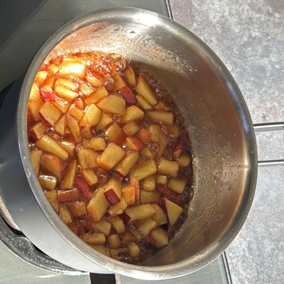 caramelising apple in a steel pot on stovetop.