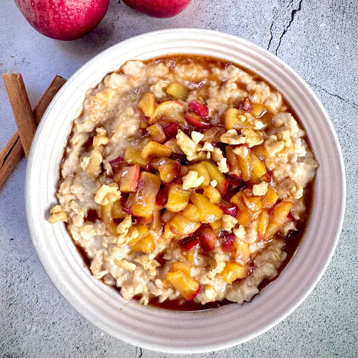 top view of white bowl of caramelised apple cinnamon oatmeal porridge.