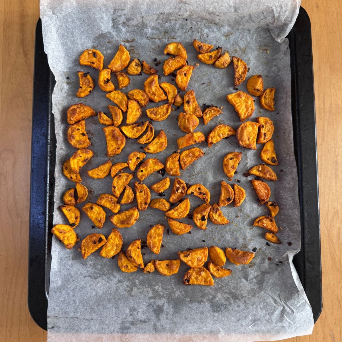 roasted sweet potato pieces on a lined baking tray